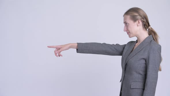 Profile View of Happy Young Blonde Businesswoman Pointing Finger