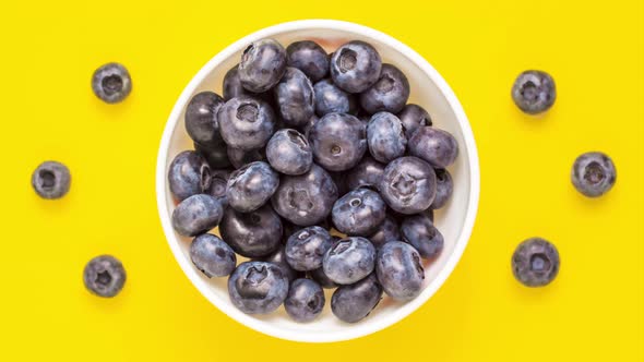 Close up blueberry disappear from white bowl on yellow background from adobe. Stop motion animation