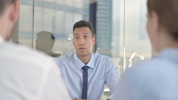 Rear Back View of Couple Having Explanation From Businessman on Office Desk