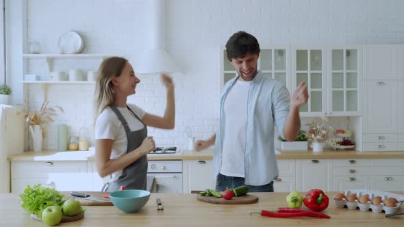 Young Couple Dancing at Home Kitchen. Preparing Food at Home, Husband and Wife Having Fun Cooking