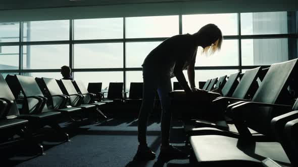 Woman Closes Her Travel Bag at the Airport Terminal