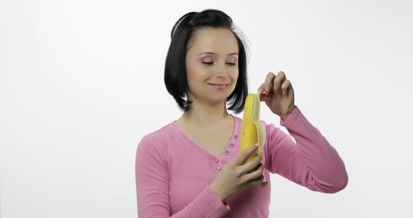 Young Woman Eating Banana and Says Yum. Girl Takes First Bite and Say Wanna Bite