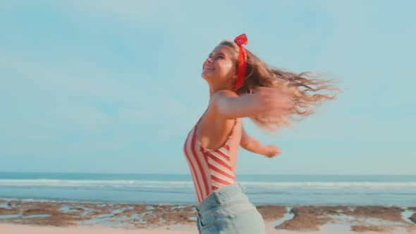 Happy Young Blonde Caucasian Women Spinning Standing Still Relaxing on the Beach