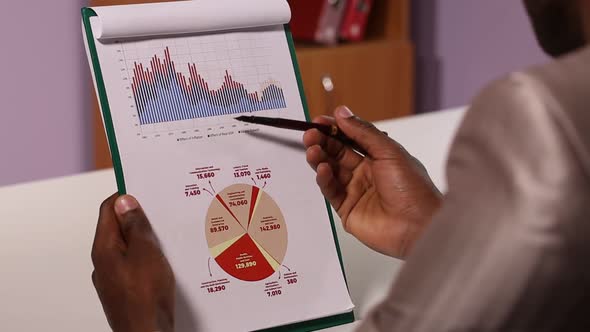 Businessman Examines Charts and Diagrams