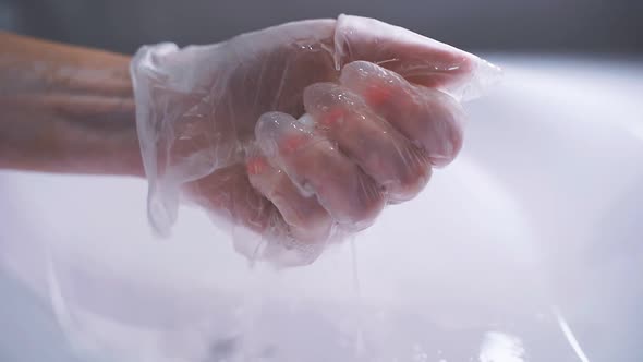 Woman's Gloved Hand Squeezes Water From a Rag Into the Bathroom Sink, Daily Disinfection and