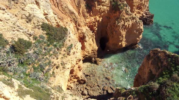 Small little birds flying through Lagos Grottos on Algarve eroded coastline