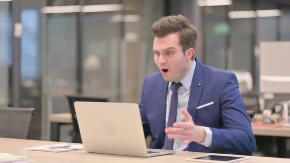 Businessman Reacting to Loss While Using Laptop