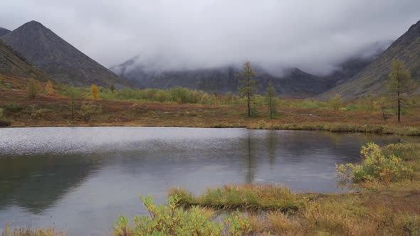 Thick Clouds Float Low Over the Mountain Lake