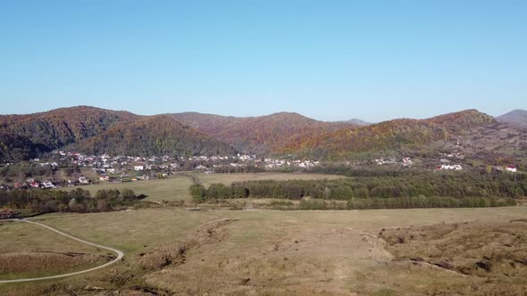 Aerial view of country hills at sunset in autumn season. Beautiful rural scene with dead nature, ear