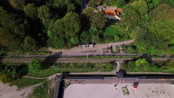 Drone Over Sea And Train Track Next To Lush Urban Forest