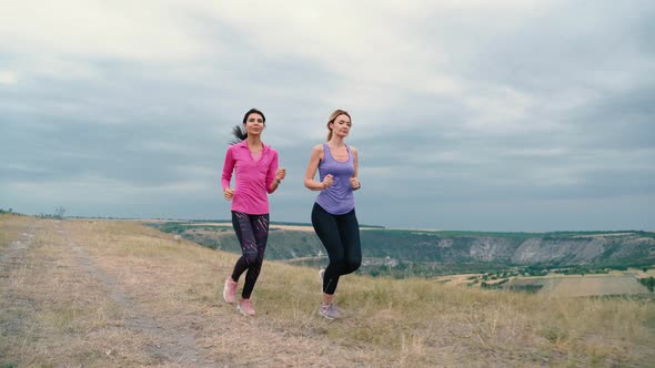 Two Young Women are Exercising with Outdoor Running When the Sun Sets in in Summer