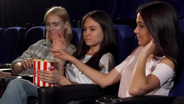 Young Woman Annoyed By Her Friends Eating Her Popcorn at the Cinema