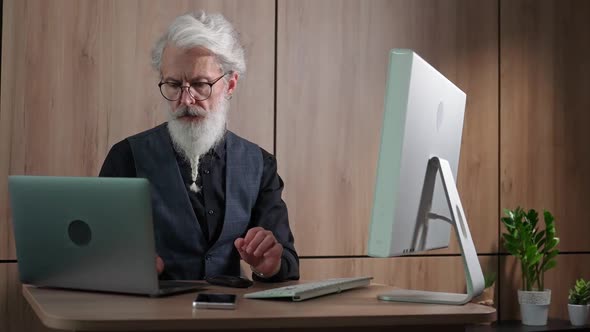 Grayhaired Man Designer Works in the Office at the Computer an Adult Man in the Process of Work