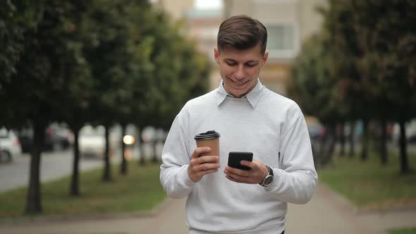 A Man is Walking and Texting on a Smartphone