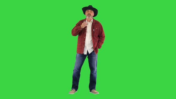 Bearded Man in Cowboy Hat Drinking Expensive Whisky on a Green Screen Chroma Key