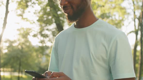 Young Afro-American Man Messaging on Smartphone Outdoors