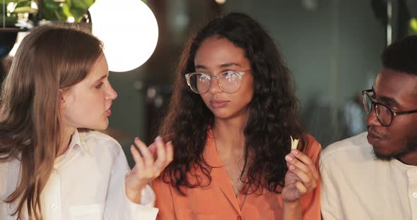 Close Up View of Young People Communicating While Eating During Lunch in Modern Cafe. Millennial