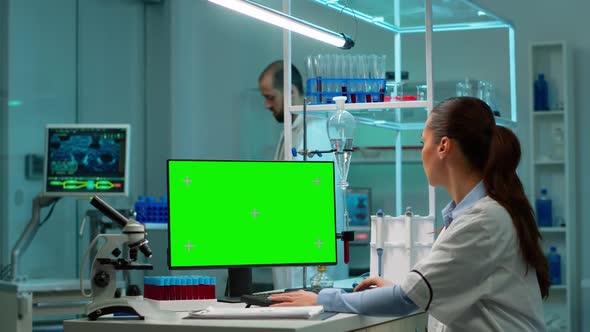 Scientist Sitting at Desk Working on Personal Computer with Mockup Screen