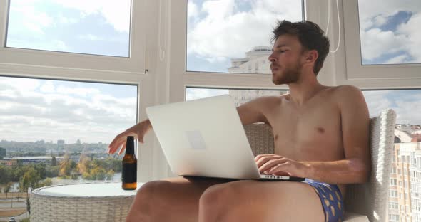 Man is playing video games and drinking beer