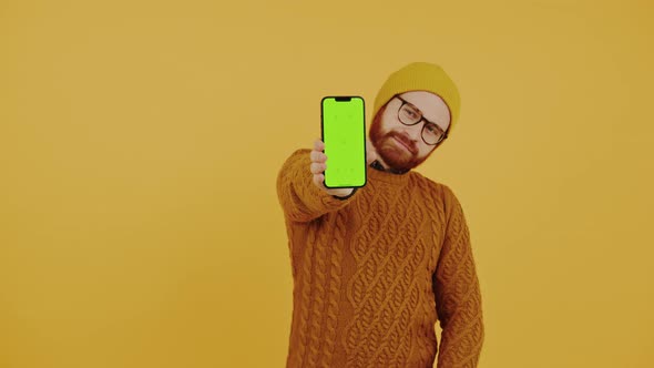 Young Man Showing the Smartphone Screen with Green Chroma Key and Showing the Thumb Up Gesture