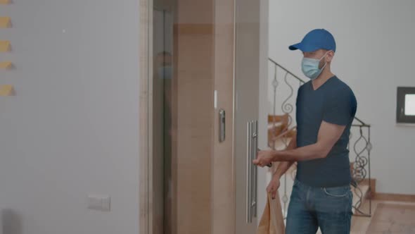 Delivery Guy with Protection Face Mask and Gloves Delivering Takeaway Food Box