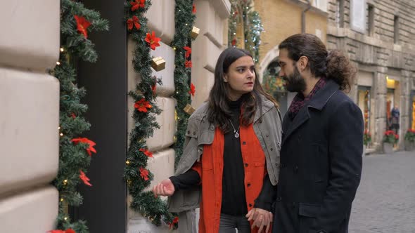 Christmas Shoppping: Young Couple in Front of A Shop Window Discussing About Gift