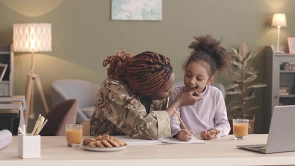 Military Woman Helping Daughter with Homework alt