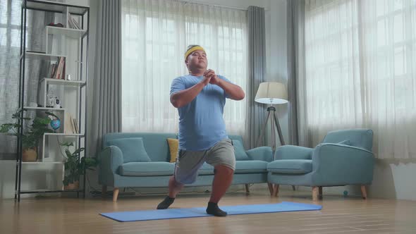 Fat Asian Man Trying To Do Yoga On Mat  At Home