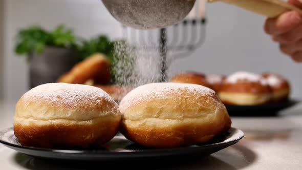 Spreading Sugar Powder On Hanukkah Doughnuts. jewish doughnuts