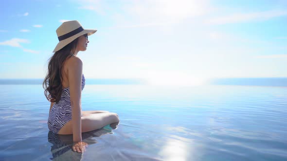 Young asian woman enjoy around outdoor swimming pool for leisure