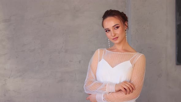 Girl Model in a White Dress Professionally Posing for the Photographer