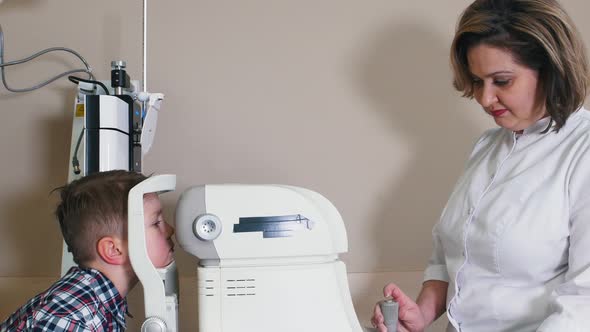 Ophthalmologist Treatment - Mature Woman Cheking Boy's Eyes