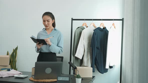 Young asian entrepreneurs check their clothes before selling them to customers.