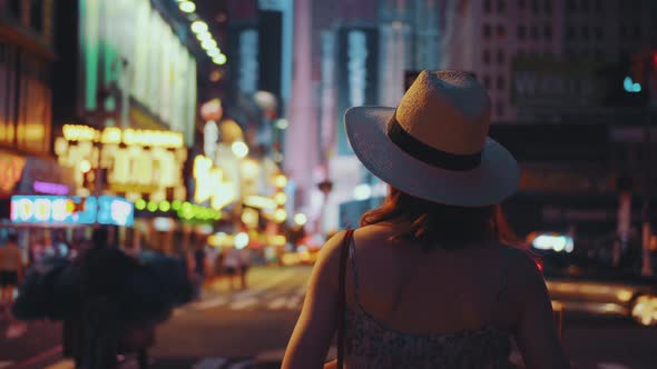Young girl with retro camera in Times Square at night