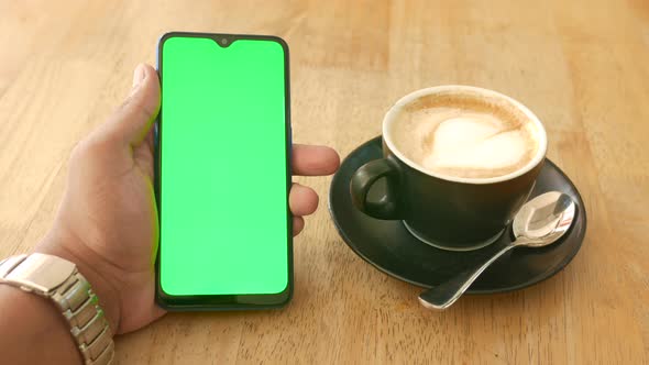 Close Up of Young Man Hand Using Smart Phone with Green Screen at Cafe