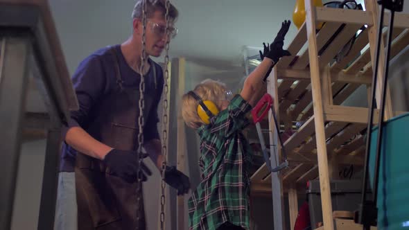 Slow Motion, Man Helps Boy To Take Tool From the Shelf 