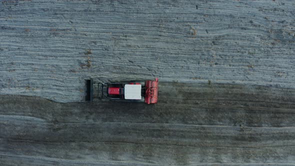 Top View of a Red Tractor Plowing a Field