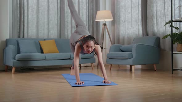 Young Asian Trainer Female In Sports Clothes Speaking And Stretching While Teaching Exercise At Home