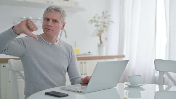 Upset Senior Old Man with Laptop Doing Thumbs Down