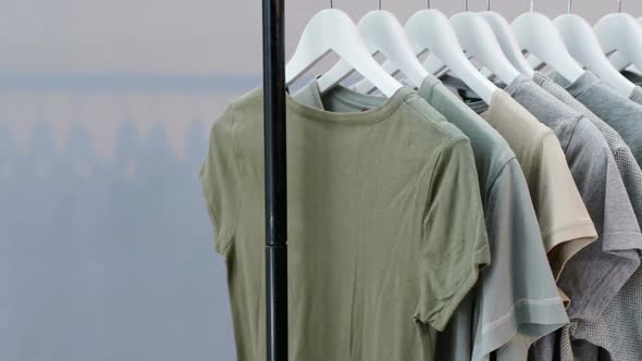 Various t-shirts arranged in a row on cloth rack 4k