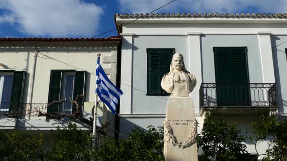 Town square with the greek flag and a statue in the village limni