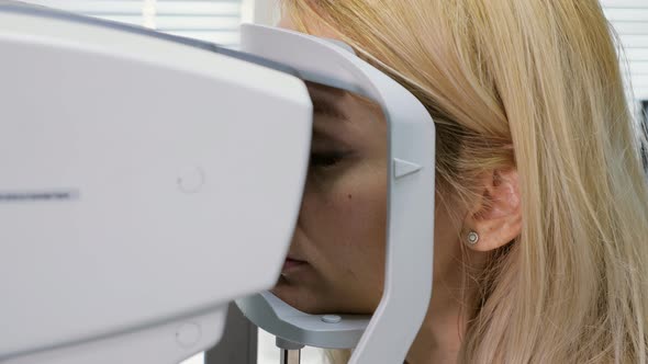 Woman Looking at Refractometer Eye Test Machine in Ophthalmology