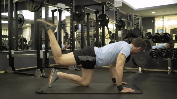 Image of a muscular man doing leg exercise at the gym.