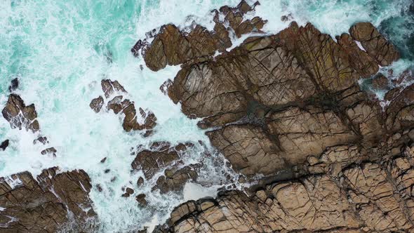Drone footage of ocean waves on rocks