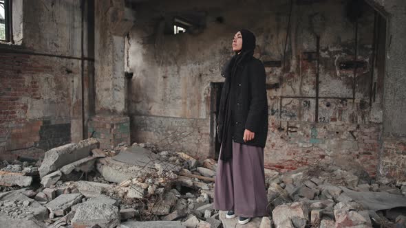 Muslim Woman Standing at Demolished House