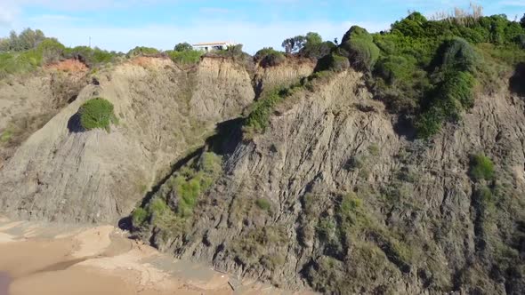 Calmer aerial drone flight fly forwards drone shot over the coastline wave in canyon to a house on c