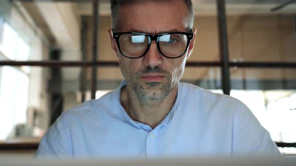 Concentrated Business Man Looking at Computer Screen Reflecting in Glasses