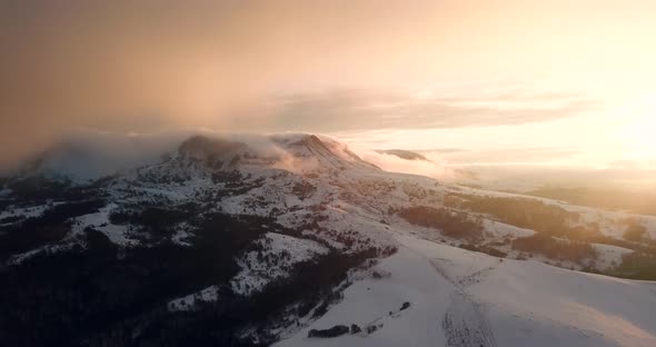 Aerial Drone Flight Over Mountain Range Through Clouds At Sunset
