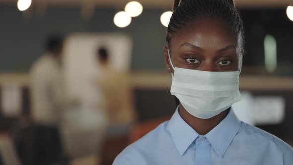 Young African American Handsome Businesswoman in Medical Mask Looking at the Camera Standing in