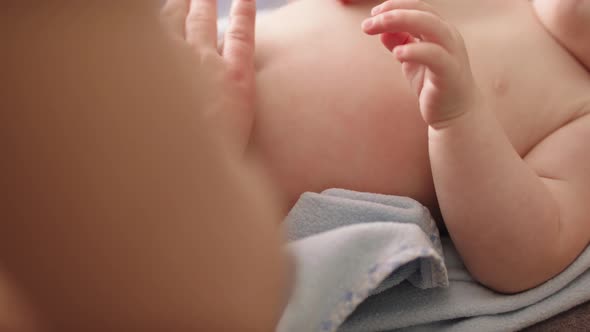 Close Up. Mother Tapping, Massaging Babys Tummy. Baby Care Concept